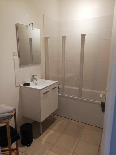 une salle de bain blanche avec un lavabo et une douche dans l'établissement logement entier au calme, à Villers-Outréaux