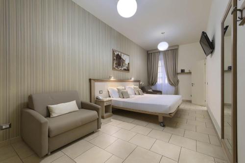 a bedroom with a bed and a couch and a chair at Domus Australia in Rome