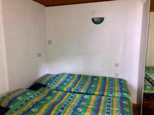 1 dormitorio con 1 cama con un edredón colorido en Casa Sibylle bei Locarno, en Locarno