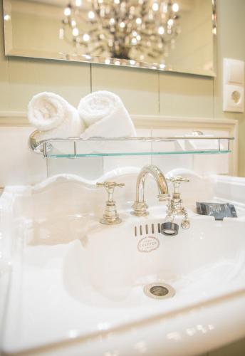a bathroom sink with a mirror and towels on a shelf at Logement Petit Beijers in Utrecht