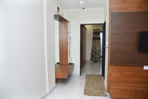 a hallway with a room with a tv and a door at Hayat-Bi Residency service apartment in Belgaum