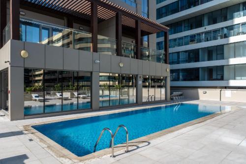 an external view of a building with a swimming pool at SUHA Mina Rashid Hotel Apartments in Dubai