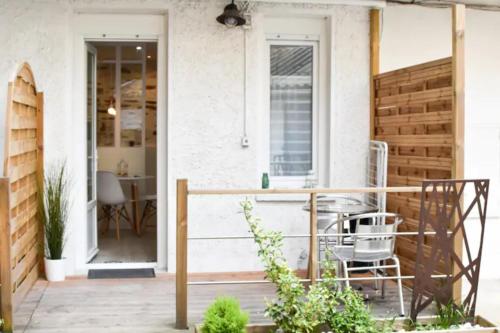 une terrasse couverte avec une table et des chaises sur une maison dans l'établissement Gîte urbain ancienne écurie au centre ville et PARKING, à Nantes