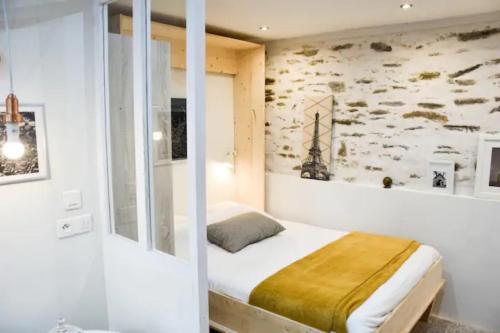 - une chambre avec un lit dans une pièce avec un mur dans l'établissement Gîte urbain ancienne écurie au centre ville et PARKING, à Nantes