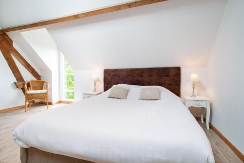 Un dormitorio con una gran cama blanca y una ventana en L'Heure Bleue gîtes et chambres d'hôtes, en Givenchy-en-Gohelle