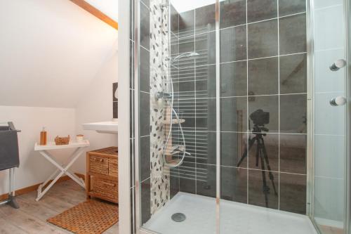 a bathroom with a glass shower with a camera at L'Heure Bleue gîtes et chambres d'hôtes in Givenchy-en-Gohelle