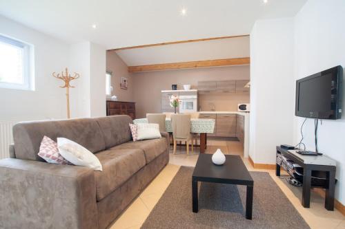 a living room with a couch and a table at L'Heure Bleue gîtes et chambres d'hôtes in Givenchy-en-Gohelle