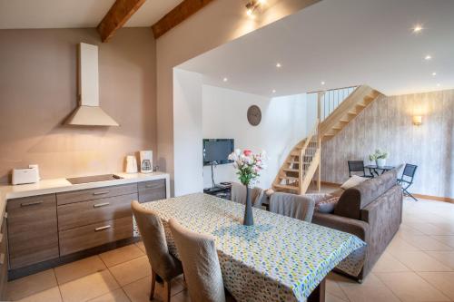 a kitchen and living room with a table and a couch at L'Heure Bleue gîtes et chambres d'hôtes in Givenchy-en-Gohelle