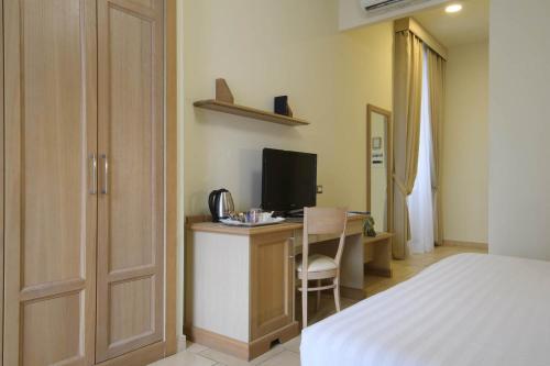a bedroom with a bed and a desk with a television at Domus Australia in Rome