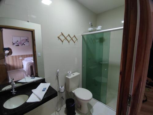 a bathroom with a toilet and a sink and a shower at HOTEL POUSADA DAS ROSAS in Carolina