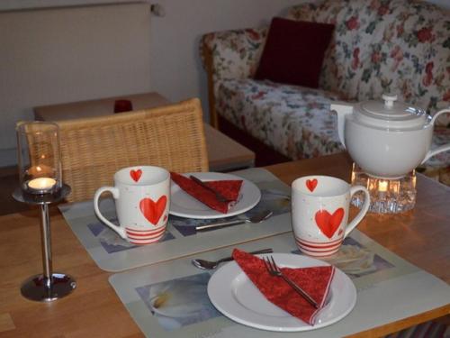 a table with two cups and plates of food at Ferienwohnung Omert in Ehrenberg