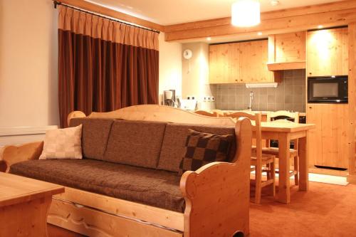 a bedroom with a bed and a kitchen with a table at Vacancéole - Résidence l'Alba in Les Deux Alpes