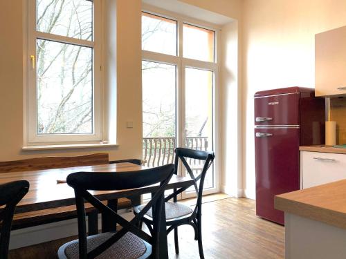 a kitchen with a table and two chairs and a refrigerator at Villa Schomberg in Spremberg