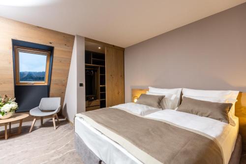 a bedroom with a large bed and a table at Hotel Monti Spa & Wellness in Igman