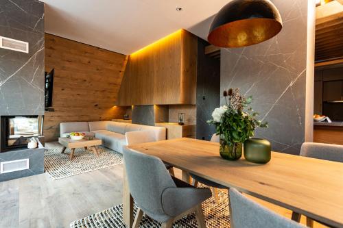 a living room with a wooden table and chairs at Hotel Monti Spa & Wellness in Igman