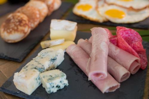 a tray of cheese and meats and eggs and bread at Villa Ilo Majunga in Mahajanga
