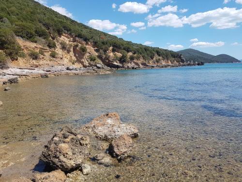 a beach with some rocks in the water at Tenuta Agricola dell'Uccellina in Talamone