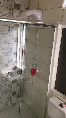 a shower with a glass door next to a toilet at Bell vale in Louro Müller