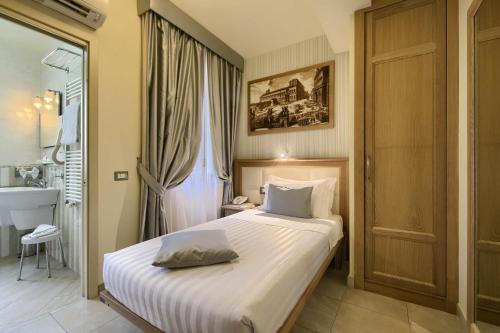 a bedroom with a white bed with a window at Domus Australia in Rome