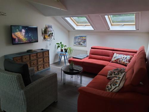 sala de estar con sofá rojo y mesa en Vakantiehuis Dartien, en Exloo