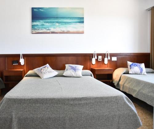 um quarto de hotel com duas camas e uma foto na parede em SolMar em San Clemente del Tuyú