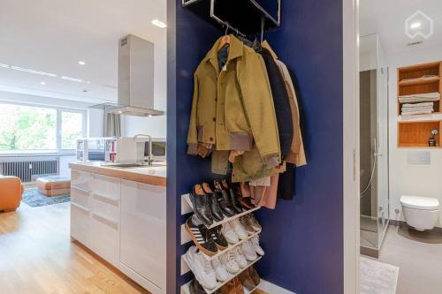 uma cozinha com uma parede azul com sapatos e sapatos em Alster 36 - Exklusives City Apartment em Hamburgo