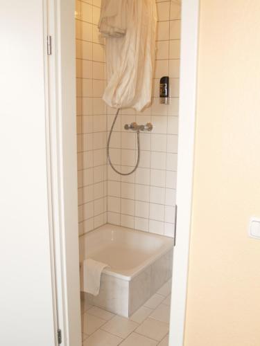 a bath tub in a bathroom with a shower at Happy Go Lucky Hotel + Hostel in Berlin