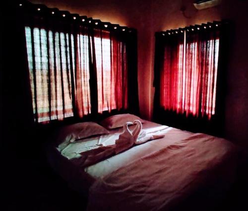 a room with a bed with two windows and a towel on it at White smoke villa in Igatpuri