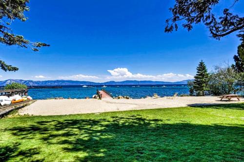 a beach with a bench and the water at Bearing Drive Escape in Tahoe City