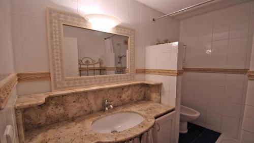 une salle de bain avec un lavabo et un miroir dans l'établissement Villa Maxime, à Sainte-Maxime