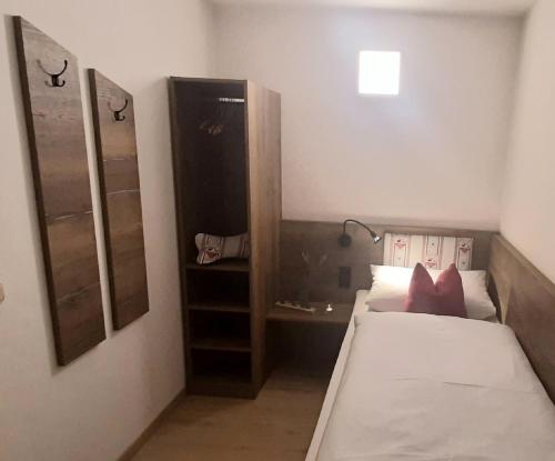 a small bedroom with a bed and a mirror at Gasthof Zum Wirt Ferienwohnung Hohenbogenblick in Neukirchen beim Heiligen Blut
