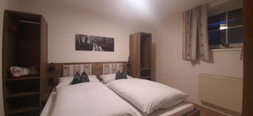 a bedroom with two white beds and a window at Gasthof Zum Wirt Ferienwohnung Hohenbogenblick in Neukirchen beim Heiligen Blut