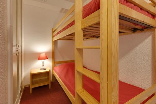 sypialnia z 2 łóżkami piętrowymi i lampką w obiekcie Vacancéole - Résidence Lauvitel w mieście Les Deux Alpes