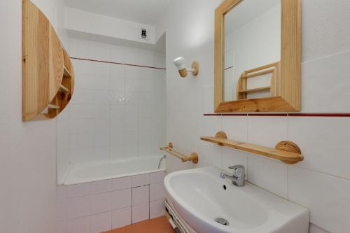 une salle de bain blanche avec un lavabo et une baignoire dans l'établissement Vacancéole - Résidence Lauvitel, à Les Deux Alpes