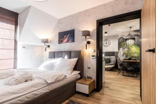 a bedroom with a large white bed with a mirror at Tatra Resort & SPA in Kościelisko