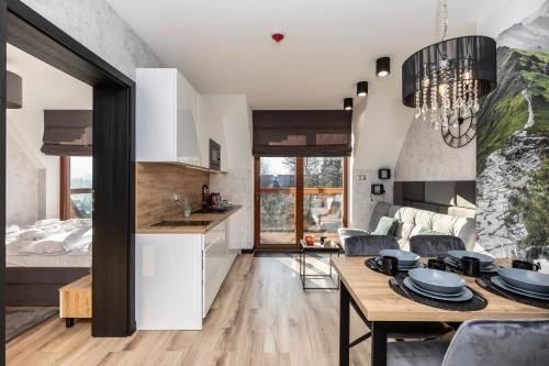 a kitchen and living room with a table and chairs at Tatra Resort & SPA in Kościelisko