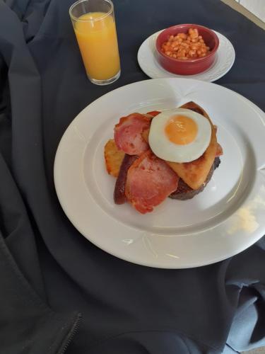 um prato de comida de pequeno-almoço com um ovo em cima em The Speyside Hotel and Restaurant em Grantown on Spey