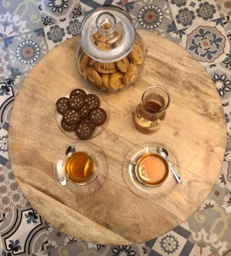 a wooden table with two cups of coffee and cookies at La Vecchia Posta B&B in Calangianus