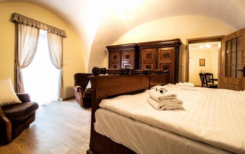 a bedroom with a large bed and a chair at Residence Tvrz Skočice in Skočice