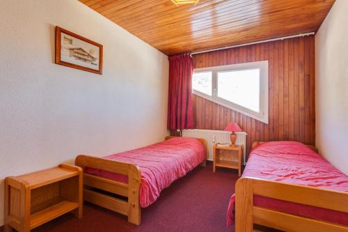 1 dormitorio con 2 camas y ventana en Vacancéole - Résidence Les Bleuets en Les Deux Alpes