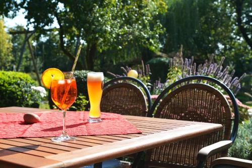 a wooden table with two glasses of drinks on it at Land-gut-Hotel Allerhof in Frankenfeld