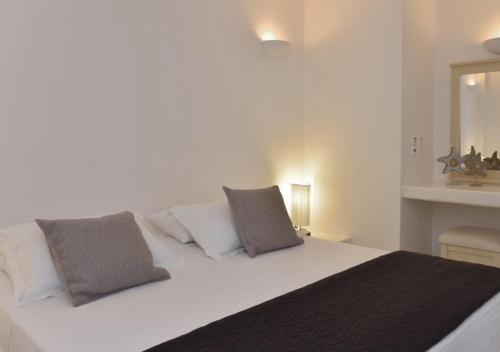 a bedroom with a large white bed with two pillows at MarKaMar in Loutraki
