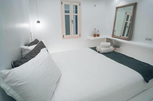 a white room with a bed and a mirror at MarKaMar in Loutraki