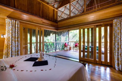 a bedroom with a bed in a room with a balcony at Sweet Songs Jungle Lodge in San Ignacio