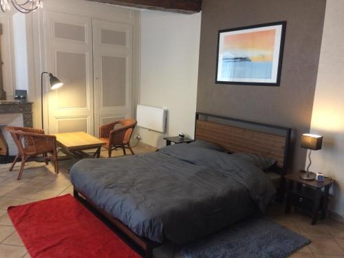 um quarto com uma cama, uma mesa e cadeiras em Chambre spacieuse au calme proche de Lyon 