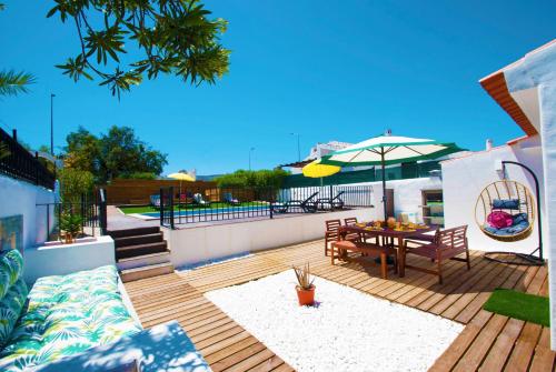 a wooden deck with a table and an umbrella at Villa São Paulo by Algarve Vacation in Albufeira