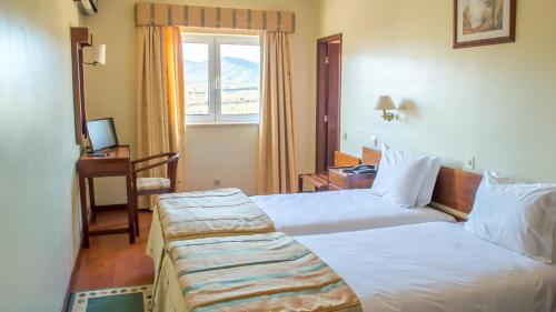 a hotel room with a bed and a window at Hotel Belsol in Belmonte