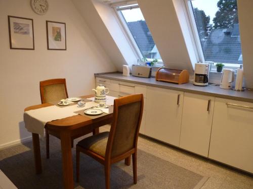 een keuken met een tafel, 2 stoelen en een aanrecht bij Ferienwohnung GOMO in Stockelsdorf
