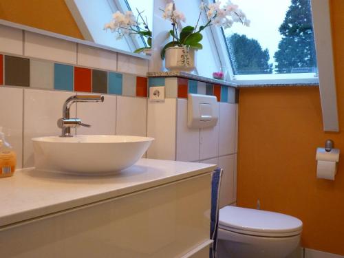 een badkamer met een wastafel en een toilet en een raam bij Ferienwohnung GOMO in Stockelsdorf