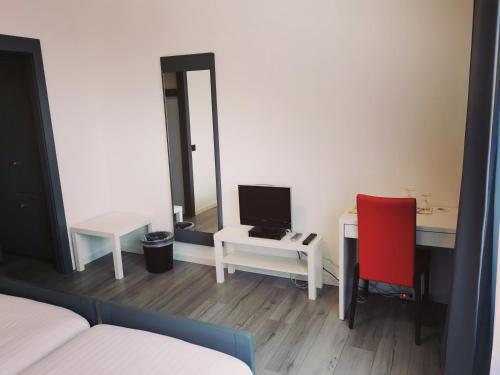 a room with a desk with a computer and a red chair at Hotel Fleur-de-Lys in La Chaux-de-Fonds